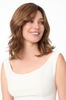 Woman wearing Amanda by Envy synthetic lace front wig in Cinnamon Toffee with soft waves and mono top.