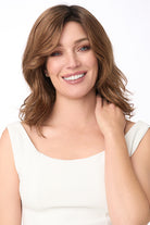 Woman smiling, wearing Amanda by Envy synthetic lace front wig in Cinnamon Toffee with soft waves.