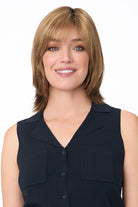 Woman wearing an Amber by Envy shoulder-length synthetic wig with layered bangs and a mono top.