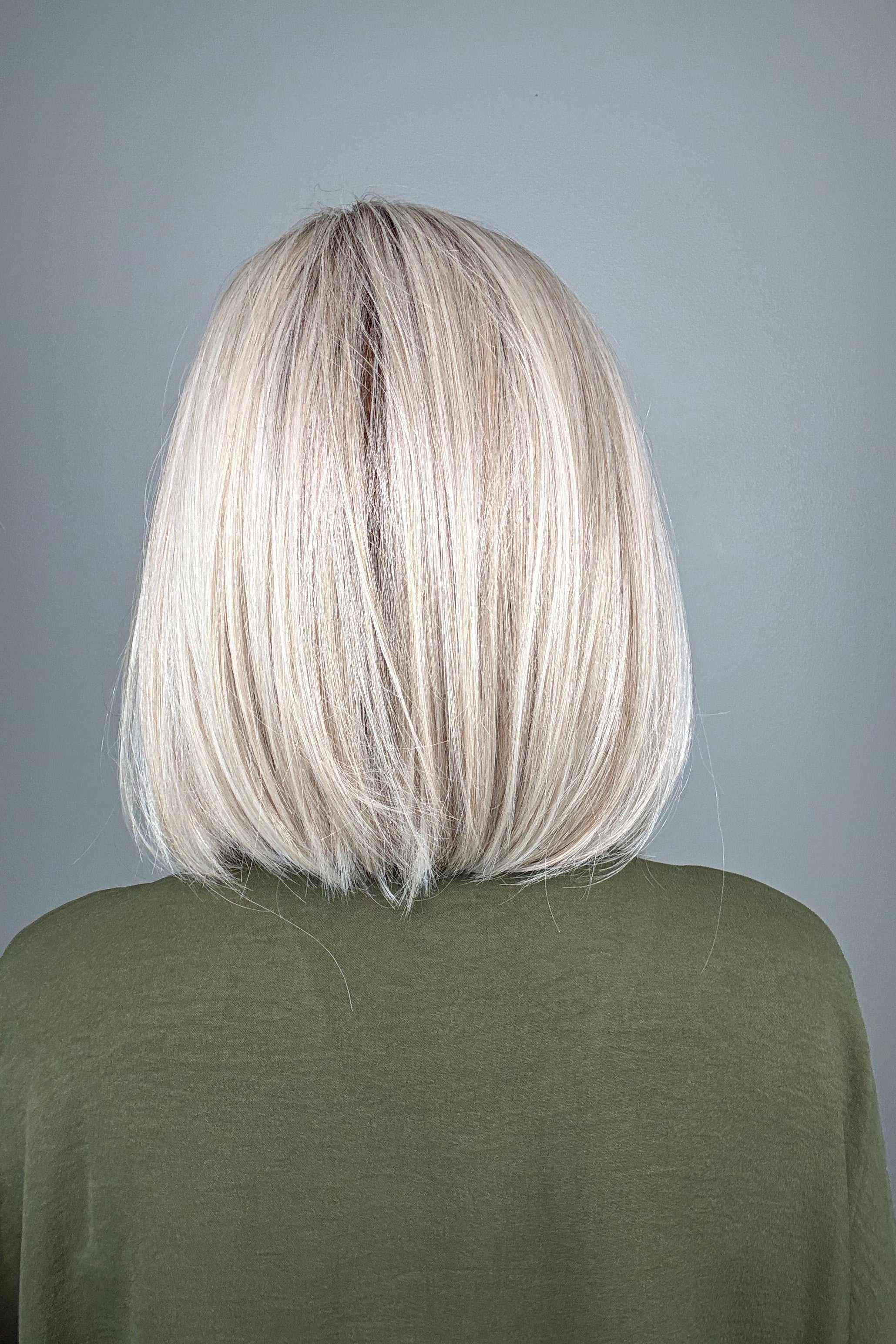 Woman wearing a shoulder length straight blonde bob (Amelie by PUSH Hair in color Roca Margarita Blonde).
