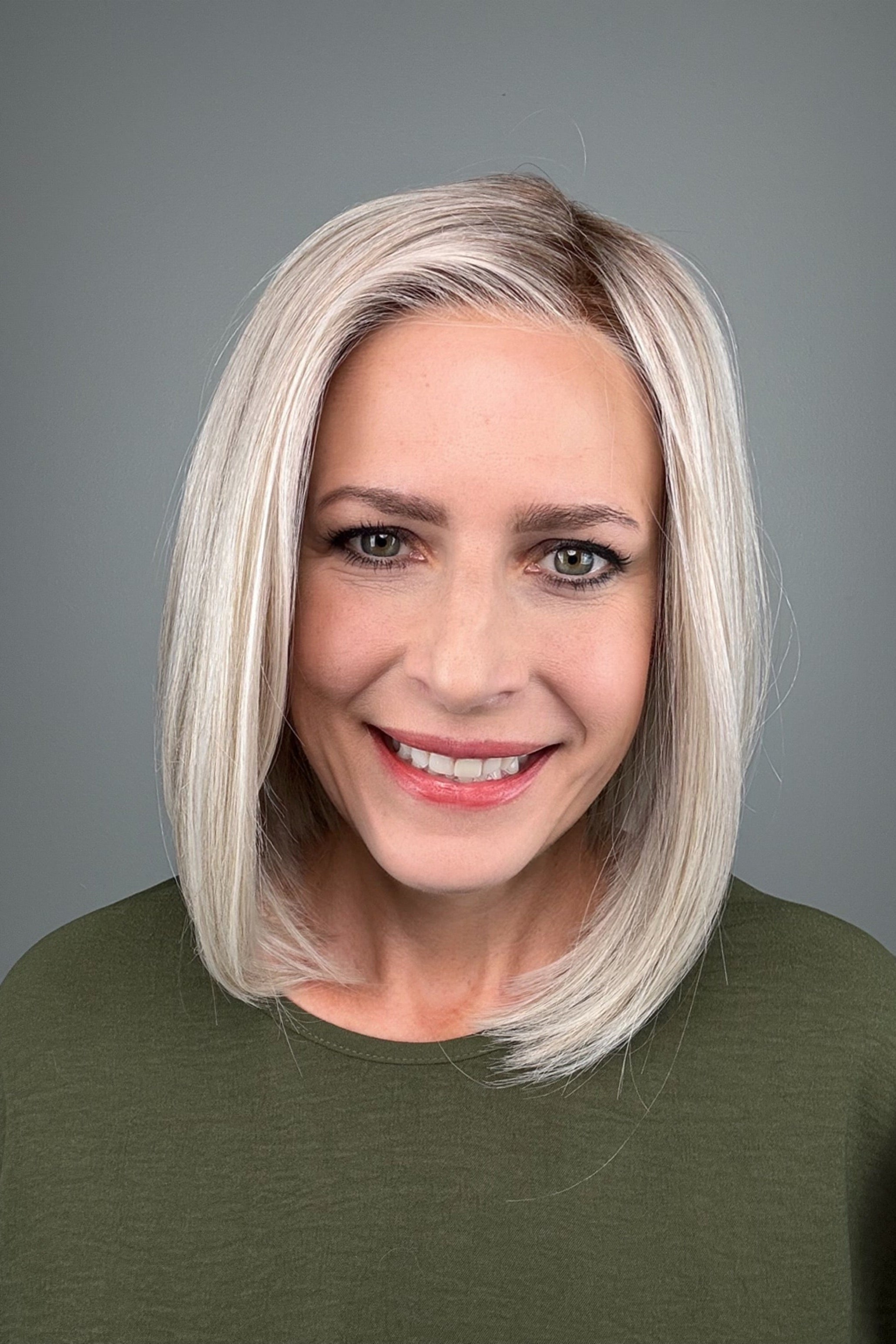 Woman wearing a shoulder length straight blonde bob (Amelie by PUSH Hair in color Roca Margarita Blonde).