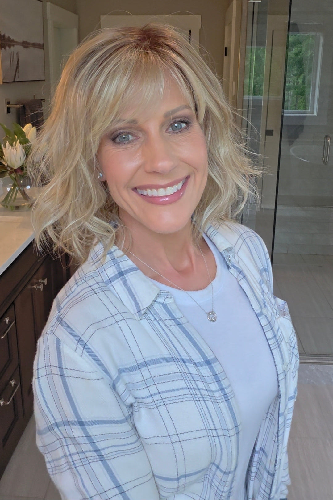 Woman wearing short wavy bob with bangs (Terra by Amore in Rose Gold R).