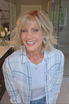 Woman wearing short wavy bob with bangs (Terra by Amore in Rose Gold R).