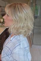 Woman wearing short wavy bob with bangs (Terra by Amore in Rose Gold R).