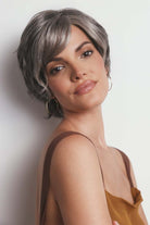 Asha synthetic pixie wig in grey with a lace front, side-swept fringe, and textured layers on a woman.