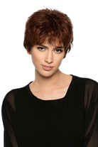 Woman wearing Aubrie synthetic pixie wig by WigPro in color 32/130 wearing a black top against a white background - front view