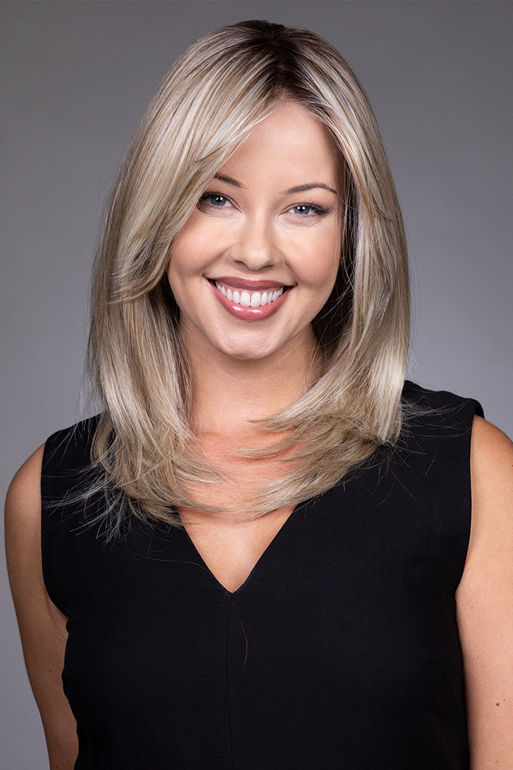 Bailey mid-length blonde layered synthetic wig with a lace front and monofilament top on a smiling woman.