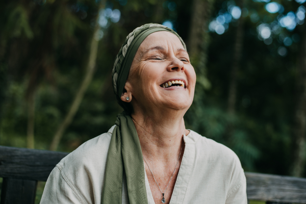 Smiling woman with eyes closed and face turned toward the sky