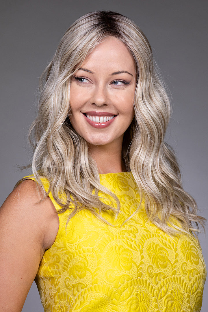 Bella by Belle Tress long blonde wavy synthetic wig with a natural lace front and monofilament top.