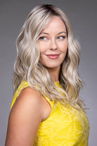 Bella by Belle Tress long blonde wavy synthetic wig with a natural lace front and monofilament top.