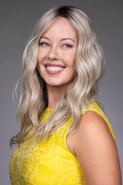 Bella by Belle Tress long wavy blonde synthetic wig with a natural lace front and monofilament top.
