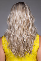 Back view of Bella by Belle Tress, a long blonde wavy synthetic wig with layered, voluminous heat-friendly fibers.