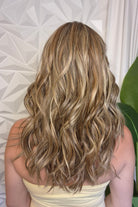 A woman with wavy blonde and brown hair wearing a pale yellow strapless top (wearing Bella by Belle Tress in color Brown Sugar Cookie R).