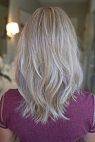 A woman with shoulder-length wavy blonde wig (Monaco by Belle Tress in color Milkshake Blonde R).