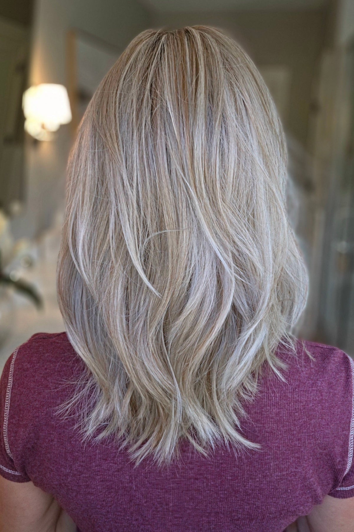 A woman with shoulder-length wavy blonde wig (Monaco by Belle Tress in color Milkshake Blonde R).