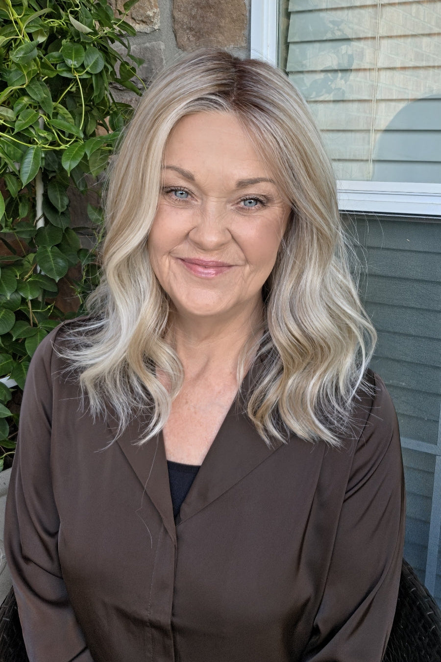 A woman with shoulder-length blonde wavy wig (Karlie by Belle Tress in Butterbeer Blonde R).