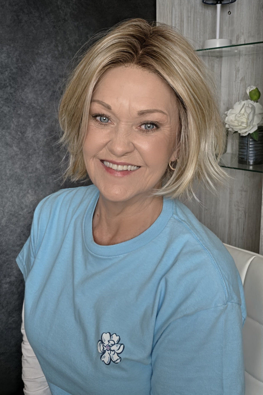 A  woman wearing chin length wispy blonde wig (Oslo by Belle Tress in color Milkshake Blonde R).