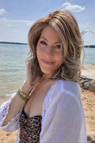 Woman wearing shoulder-length curly wig (Morgan by Belle Tress in color Buttered Toast).