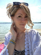 Woman wearing shoulder-length curly wig (Morgan by Belle Tress in color Buttered Toast).