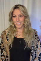 A woman with long blonde wavy wig withh bangs (Muse by Belle Tress in color Butterbeer R).