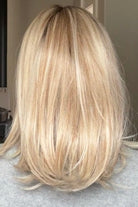A woman with shoulder-length blonde wig (Adriana by Belle Tress in color Butterbeer Blonde)