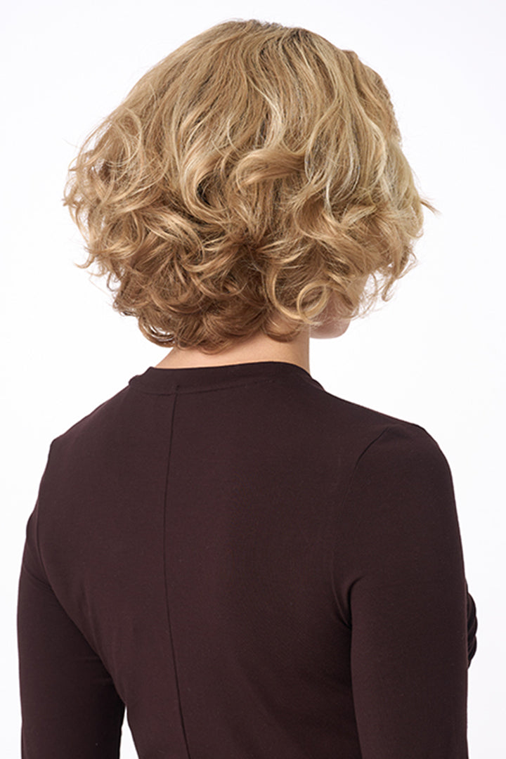 Rear view of Bianca by Envy mid-length curly synthetic wig in a blonde shade.