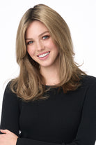 Woman smiling, wearing Bobbi by Envy long layered synthetic lace front wig in blonde.