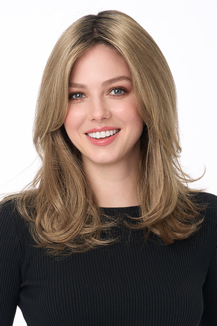 Bobbi by Envy long layered synthetic lace front wig in a warm blonde shade on a smiling woman.