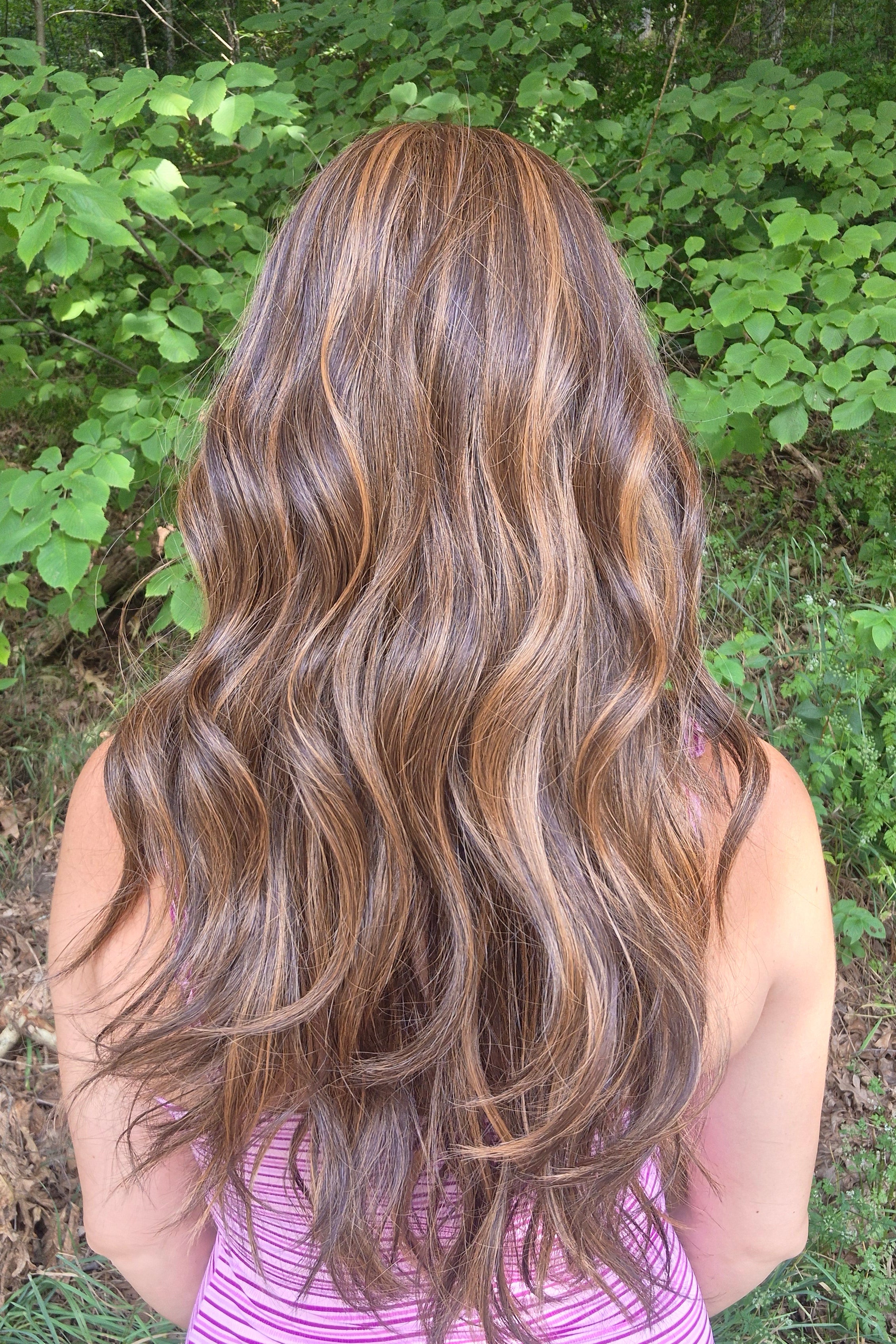 Woman wearing extra long wavy brunette wig (Bradley by PUSH Hair in color Sunlit Brunette).