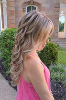 Woman wearing long layered wig with beachy waves (Brianna Hand-Tied in Prosecco).