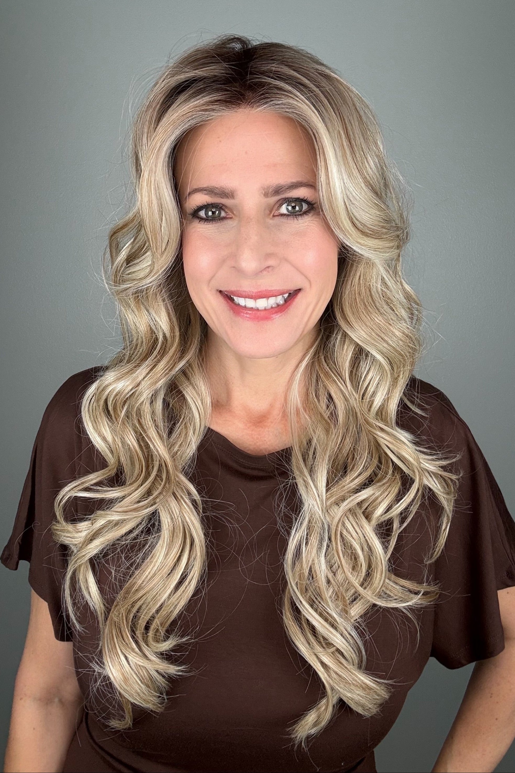 Woman wearing long curly rooted blonde wig (Carolina by Belle Tress in Rootbeer R).
