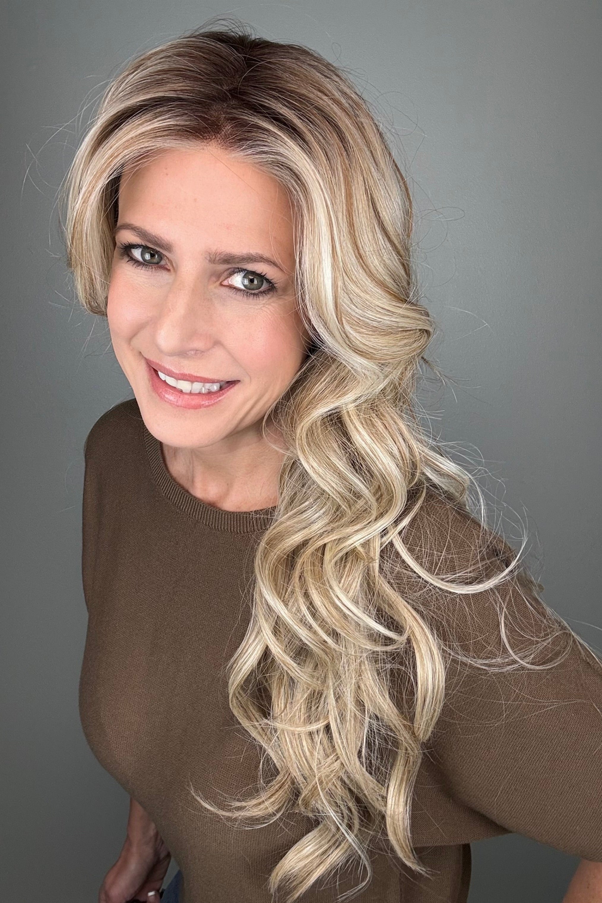 Woman wearing long curly rooted blonde wig (Carolina by Belle Tress in Rootbeer R).