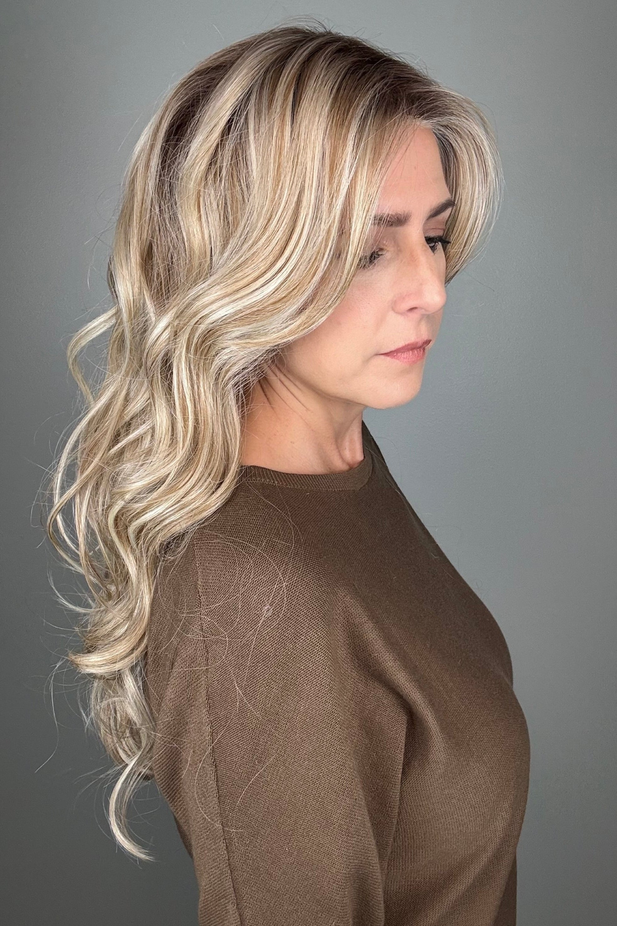 Woman wearing long curly rooted blonde wig (Carolina by Belle Tress in Rootbeer R).