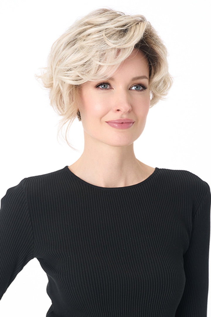 Carrisa by Envy synthetic curly blonde wig with a lace front and monofilament part on a model.