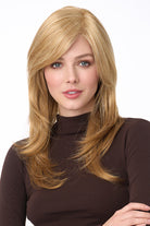 Celeste Large synthetic wig by Envy in blonde with long layers, side-swept bangs, and a natural monofilament top.