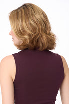 Back view of Chloe by Envy synthetic wavy layered bob wig in blonde highlights with a natural, voluminous finish.