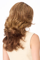 Back view of Christine by Envy synthetic wig featuring voluminous, layered light brown curls and a natural monofilament part.