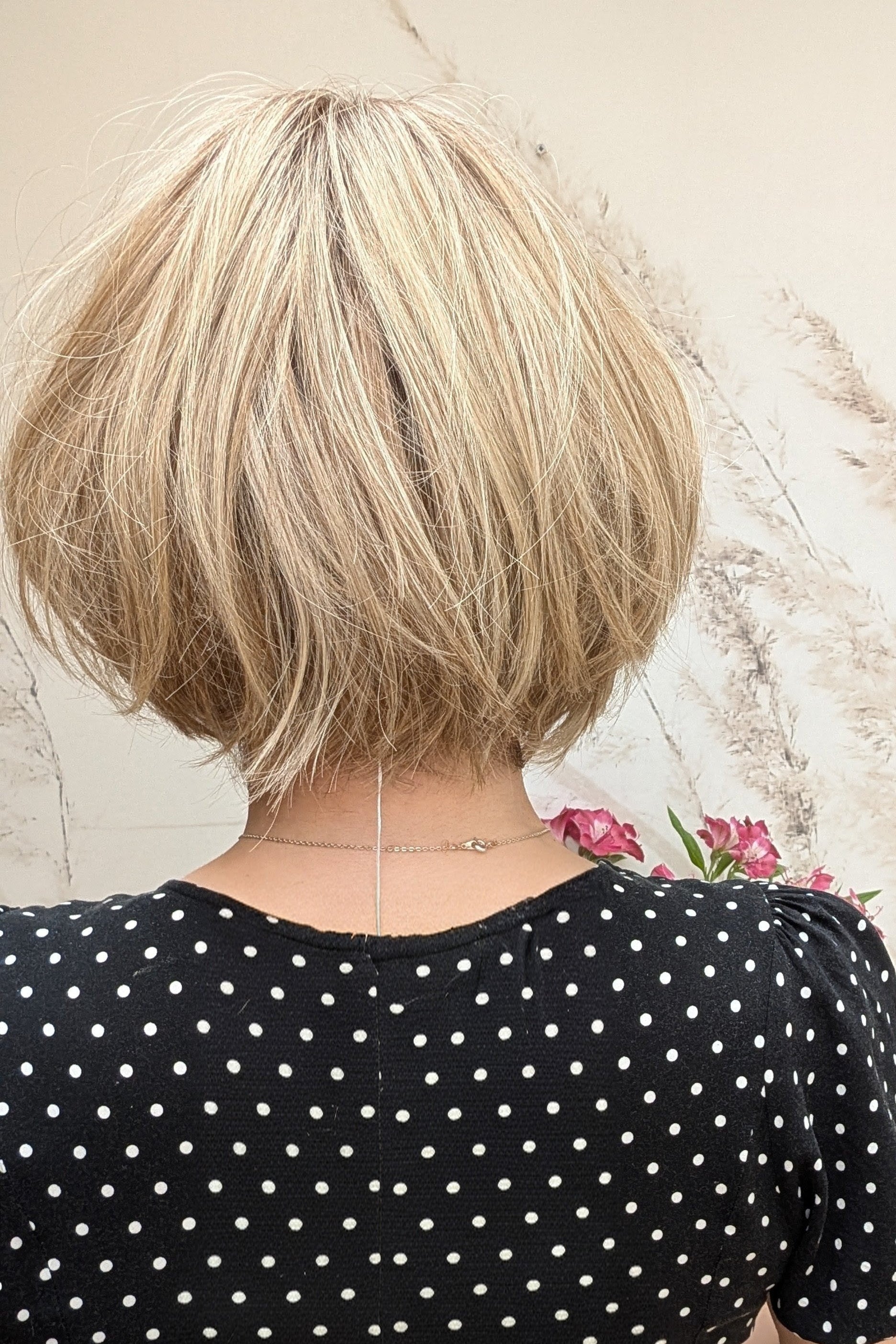 Woman wearing chin-length angled blonde bob wig (Clover by Estetica in RH18/88 RT8)