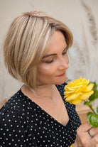 Woman wearing chin-length angled blonde bob wig (Clover by Estetica in RH18/88 RT8)