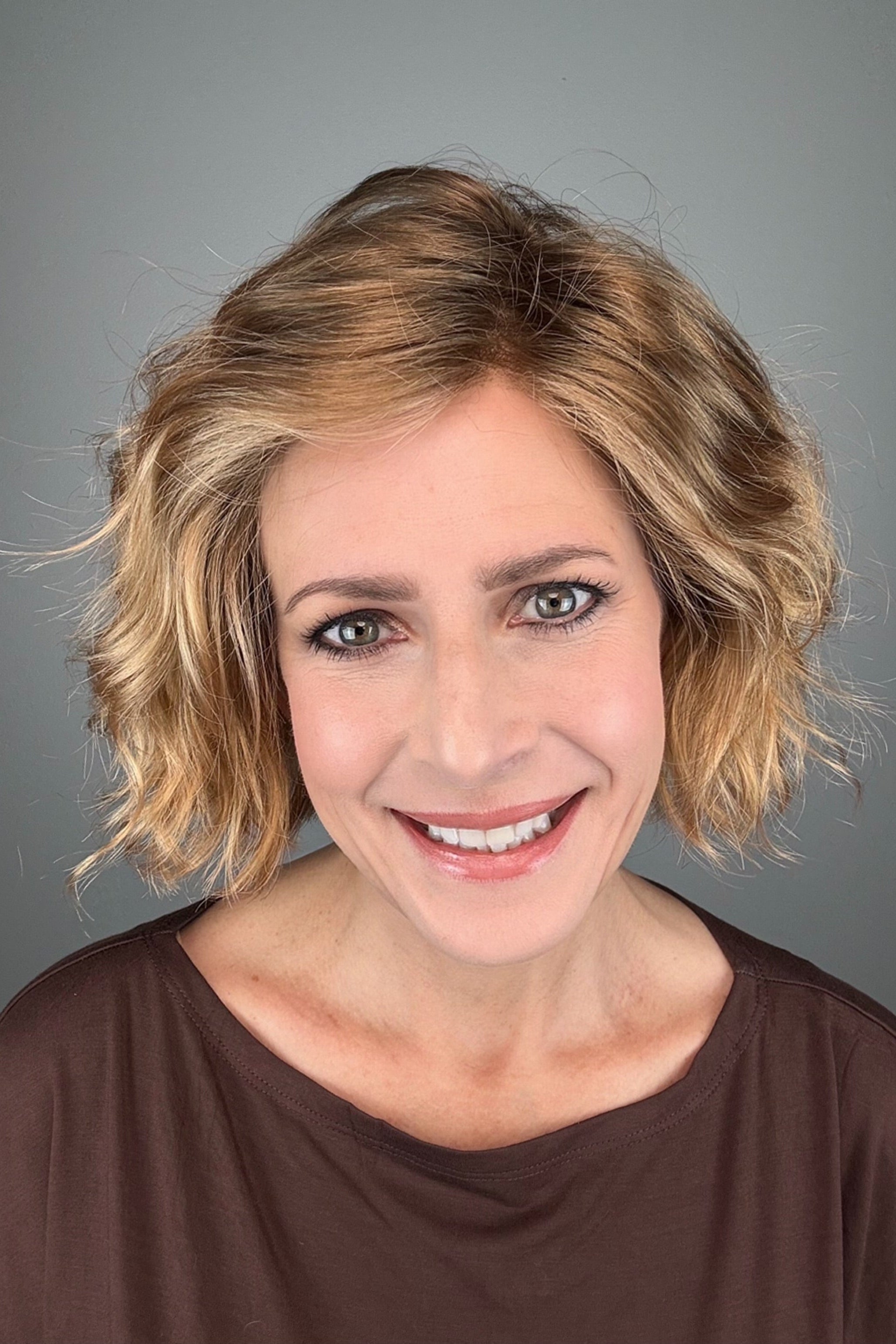 Woman wearing chin-length wavy rooted blonde bob wig (Dance by Ellen Wille in Toffee Blonde Tipped).
