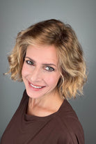 Woman wearing chin-length wavy rooted blonde bob wig (Dance by Ellen Wille in Toffee Blonde Tipped).