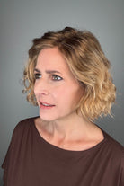 Woman wearing chin-length wavy rooted blonde bob wig (Dance by Ellen Wille in Toffee Blonde Tipped).