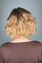 Woman wearing chin-length wavy rooted blonde bob wig (Dance by Ellen Wille in Toffee Blonde Tipped).