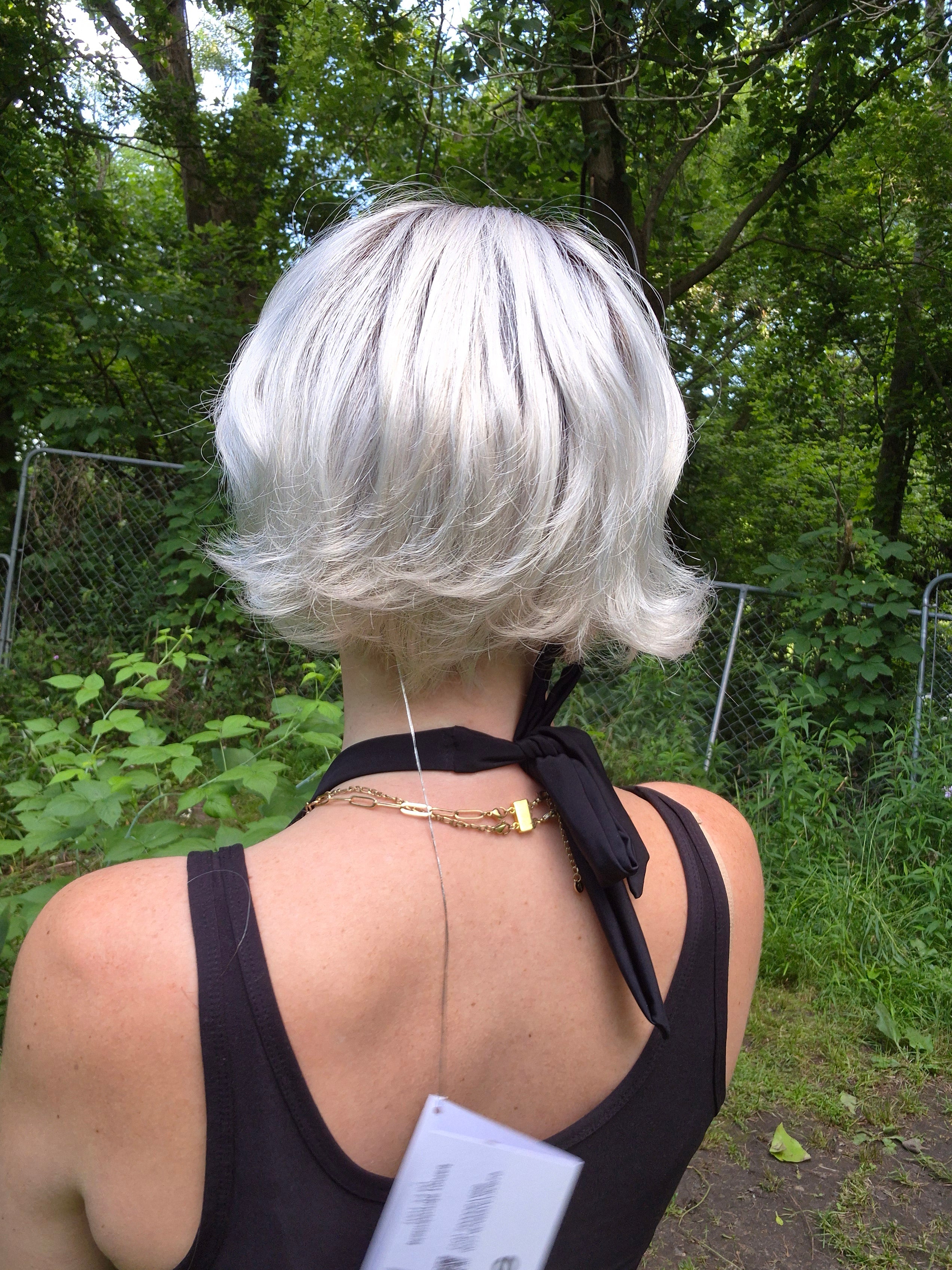 Woman wearing short chin-length blonde bob (Romance Deluxe by Ellen Wille in Platin Blonde Rooted).