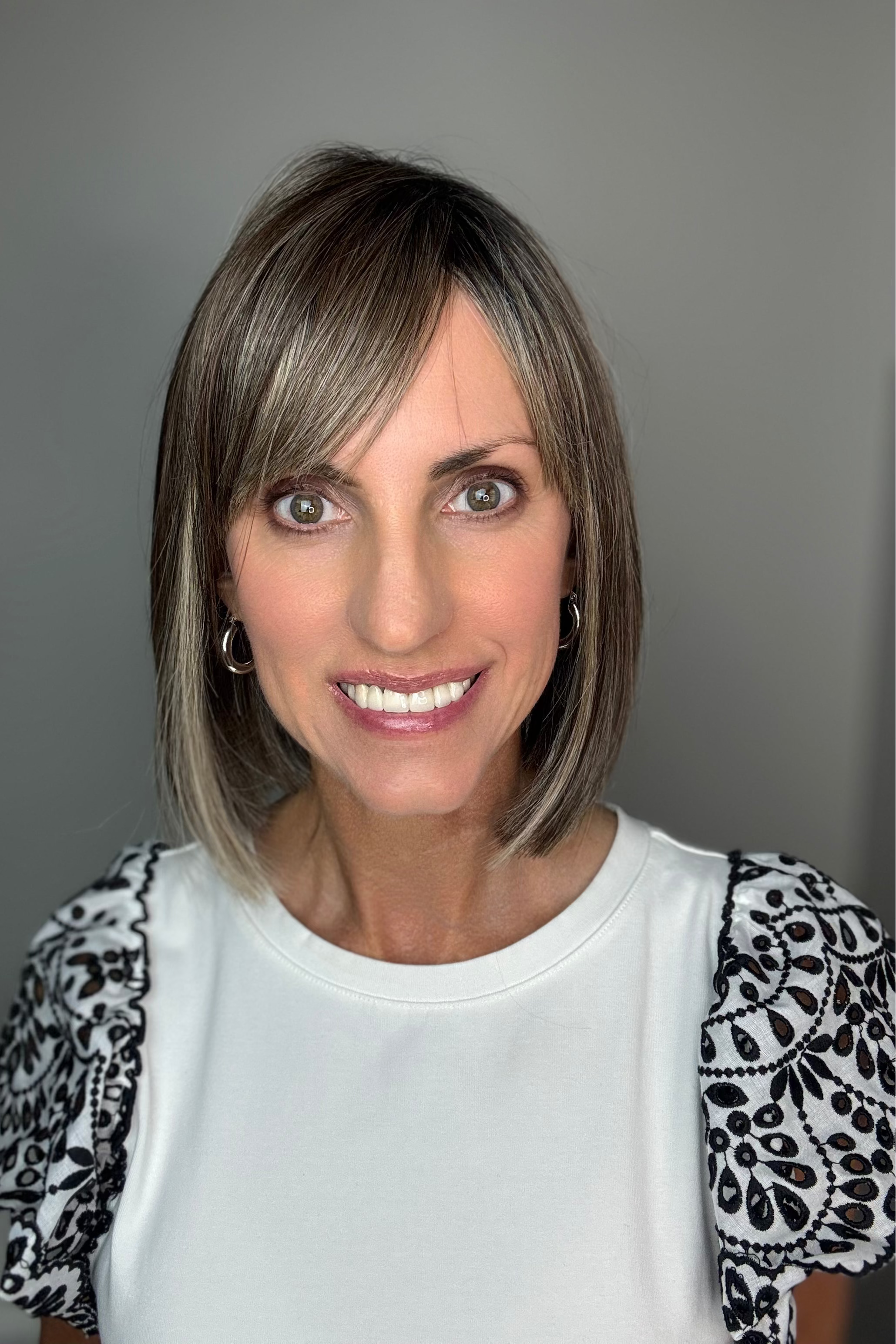 Woman wearing shoulder-length bob with bangs (Miss Comfort by Ellen Wille in Dark Sand R)