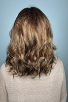Woman with shoulder-length brown wavy bob wig (Energy by Gabor in Hazelnut)