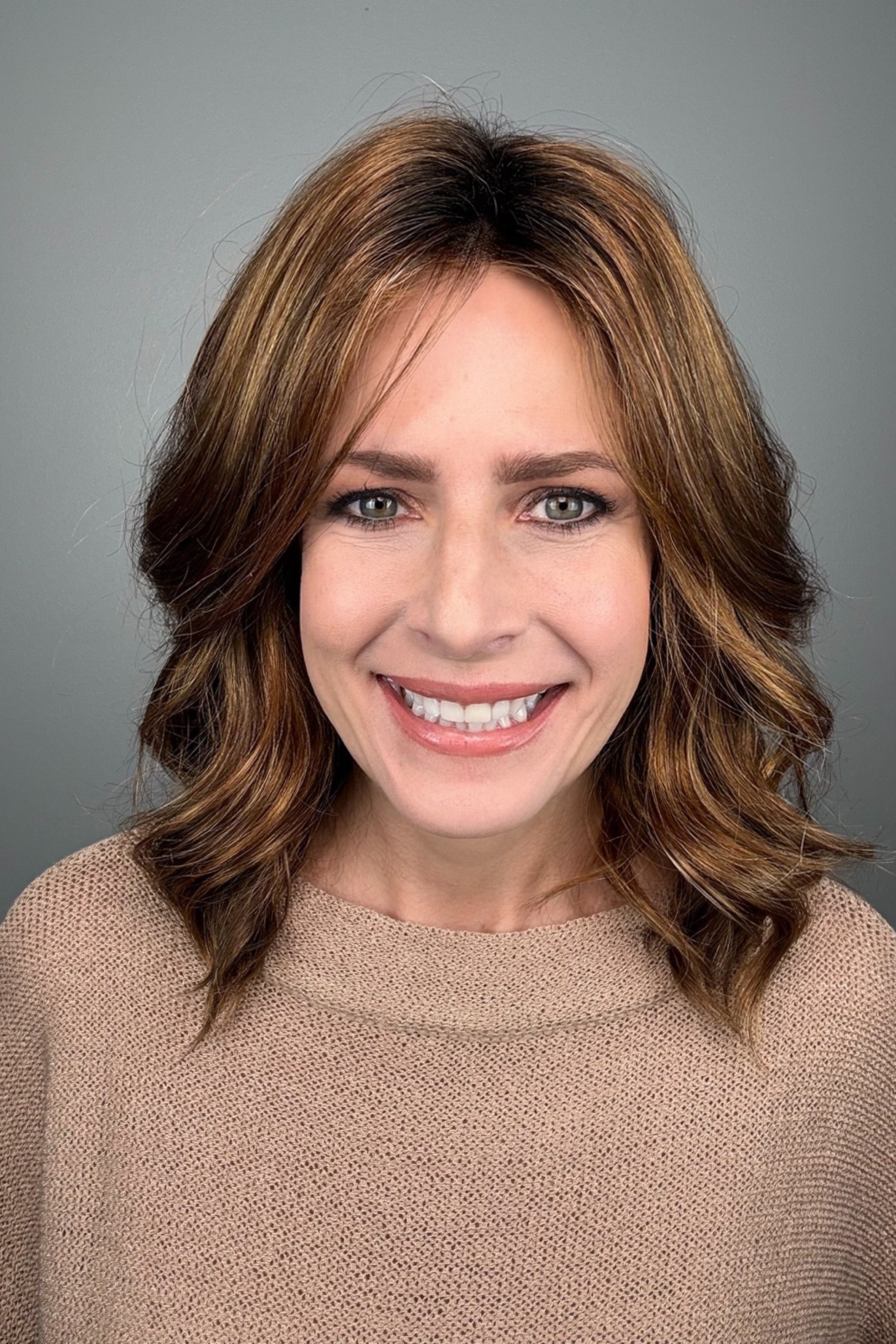 Woman with shoulder-length brown wavy bob wig (Energy by Gabor in Hazelnut)