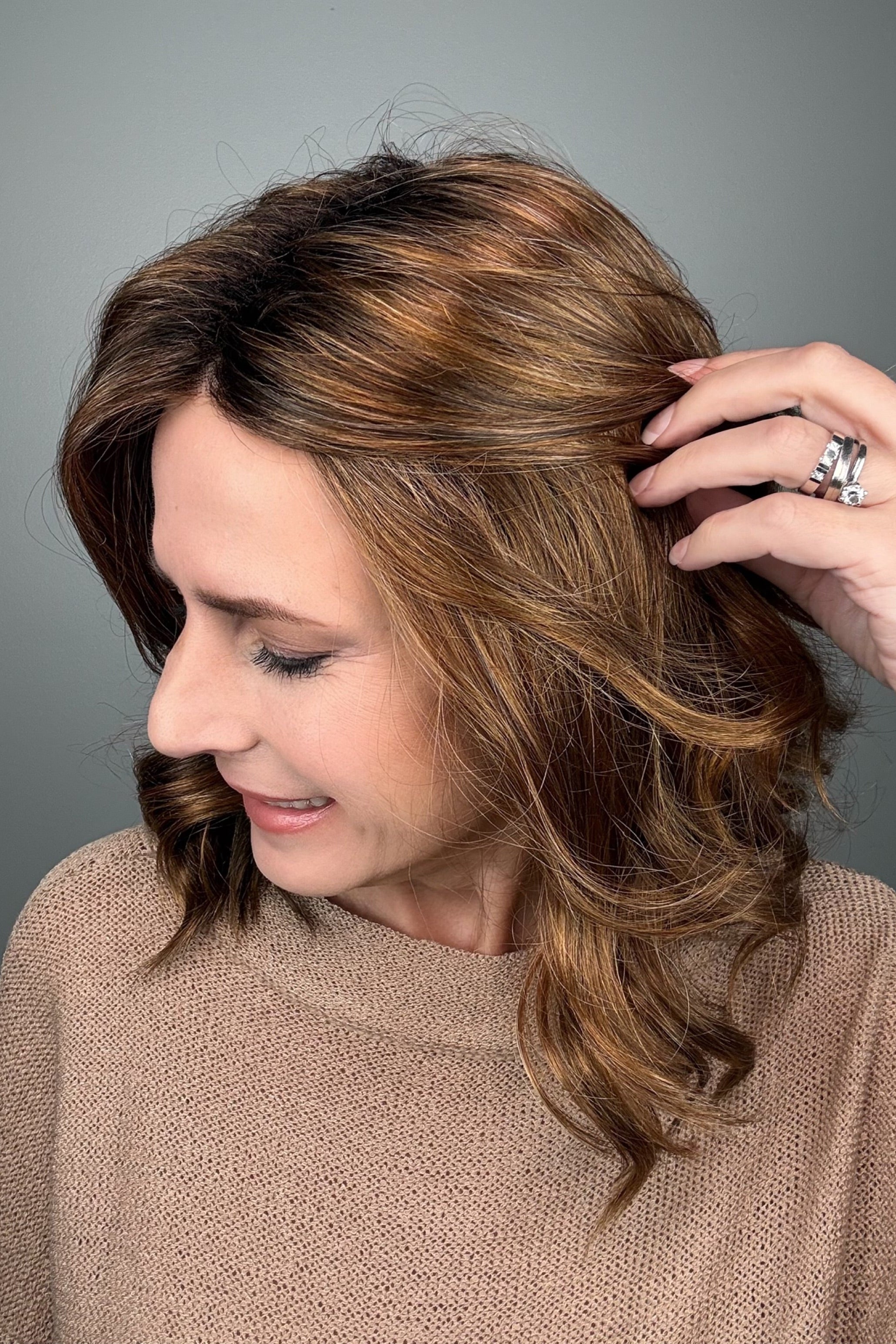 Woman with shoulder-length brown wavy bob wig (Energy by Gabor in Hazelnut)
