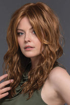 Woman wearing Verona Synthetic Wig in color R30/28/26 by Estetica with a white background and green top top.