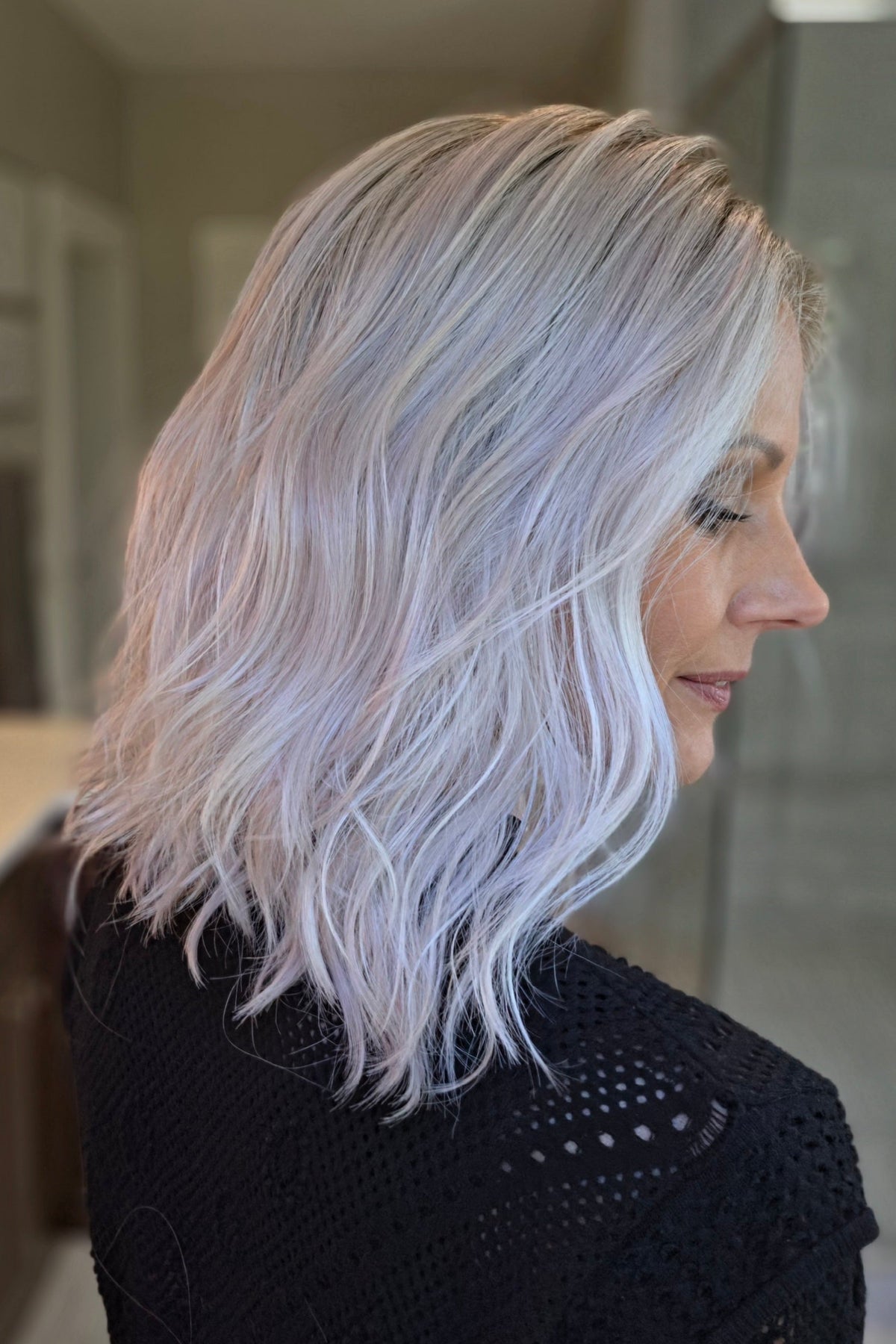 A woman with shoulder-length wavy pink wig (Somers by Estetica in Polarizing Pink).
